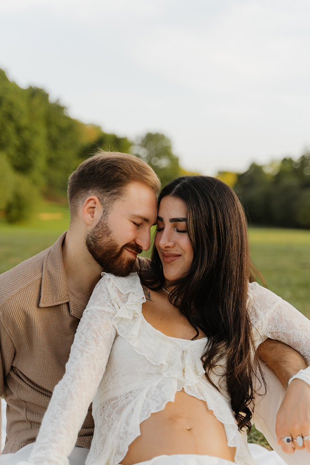 Paar kuschelt beim Babybauchshooting im Abendlicht