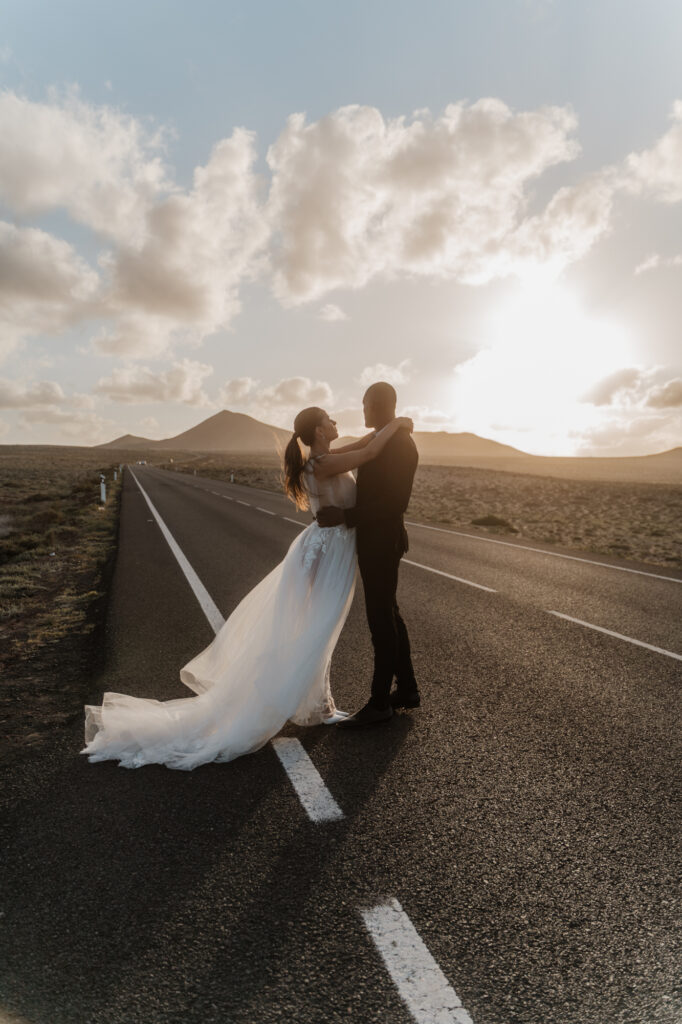 Brautpaar auf einer leeren Straße durch die Vulkanlandschaft von Lanzarote